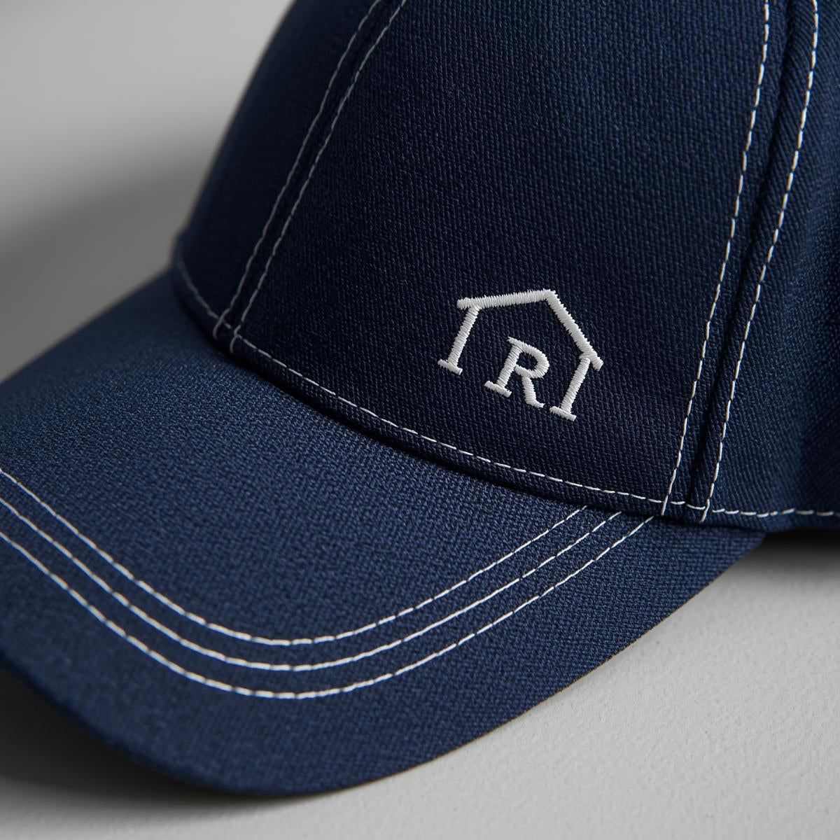 Navy blue cap with a logo on a light gray background